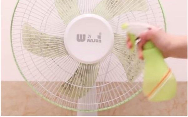 Dùng bình xịt để phun dung dịch làm sạch lên cánh quạt